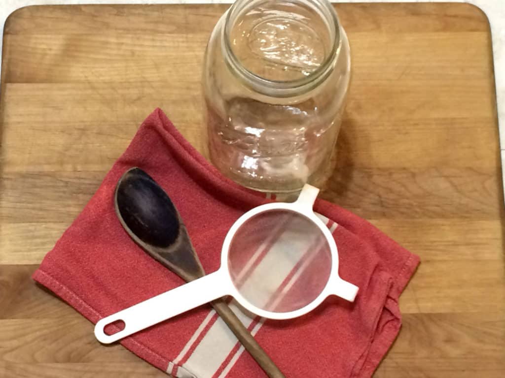 tools to use wooden spoon nylon mesh strainer glass jar tea towel