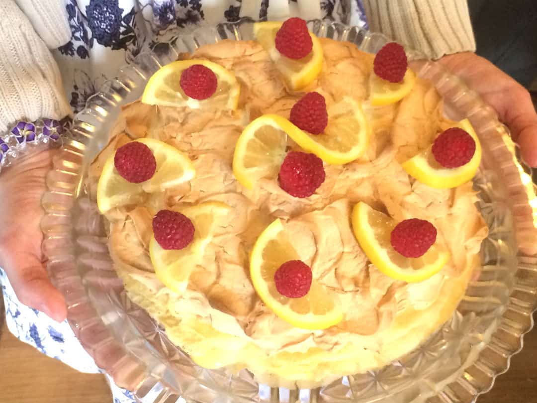 Farmhouse Lemon Meringue Sourdough Crepe Cake decorated with lemons and raspberries #lemon #spring #dessert #sourdough #realfood #fromscratch