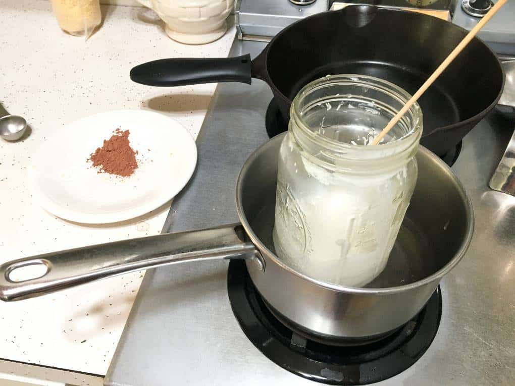 quart mason jar melting sunscreen ingredients in a pot on the stove